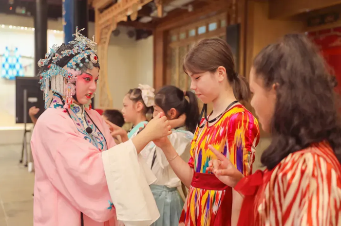 “书香之旅”亲子研学团中，昆曲老师在指导学生动作。