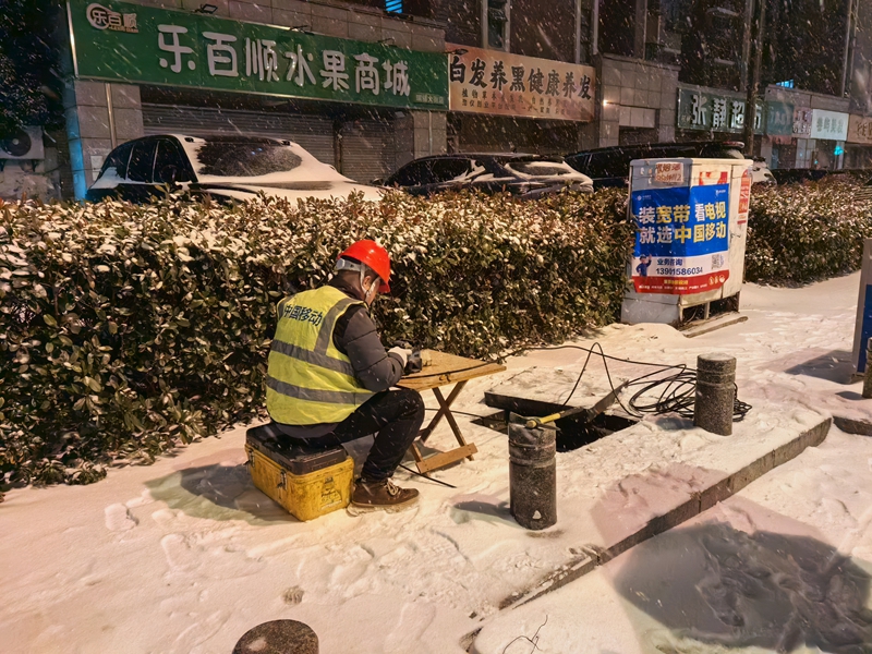 工作人員在雪地搶修寬帶線路。