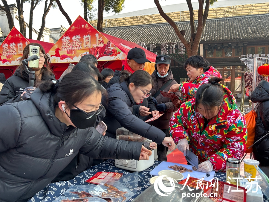 市民游客试吃刚出锅的腊肠。人民网记者 王丹丹摄