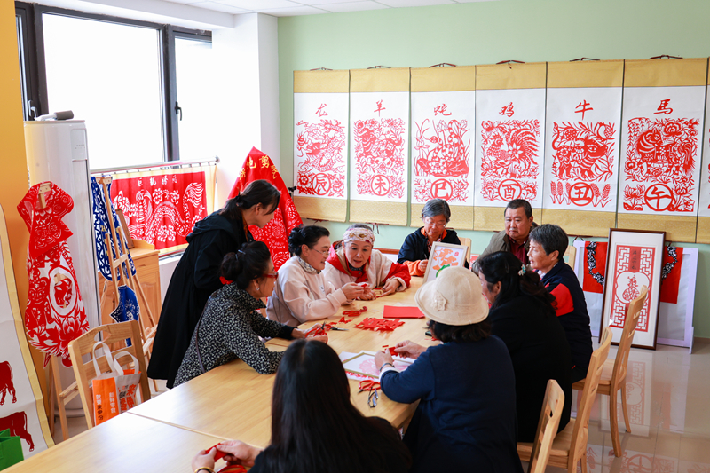 沪苏两地居民在小区内切磋剪纸技艺。昆山市委组织部供图