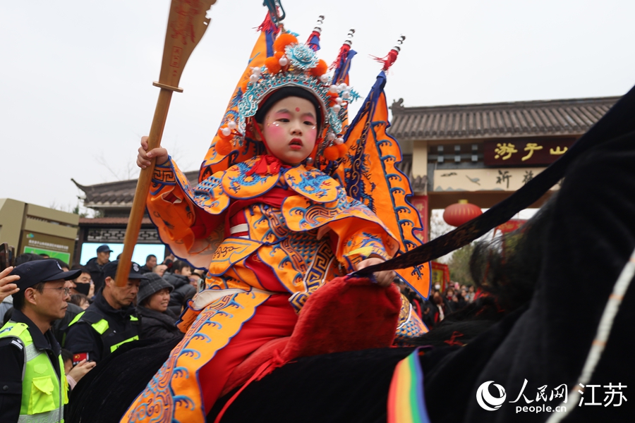 小演员们身着民俗服饰，骑着由人扮演的马匹，在游子山上演出。人民网 崔小倩摄