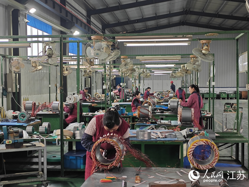 微特电机老车间内，工人在手工嵌线。为突破产能瓶颈，增资扩产项目已上马。人民网李欣阳摄