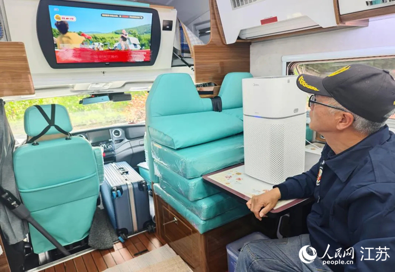 朱保堂在房车里看电视。人民网记者 常雨薇摄