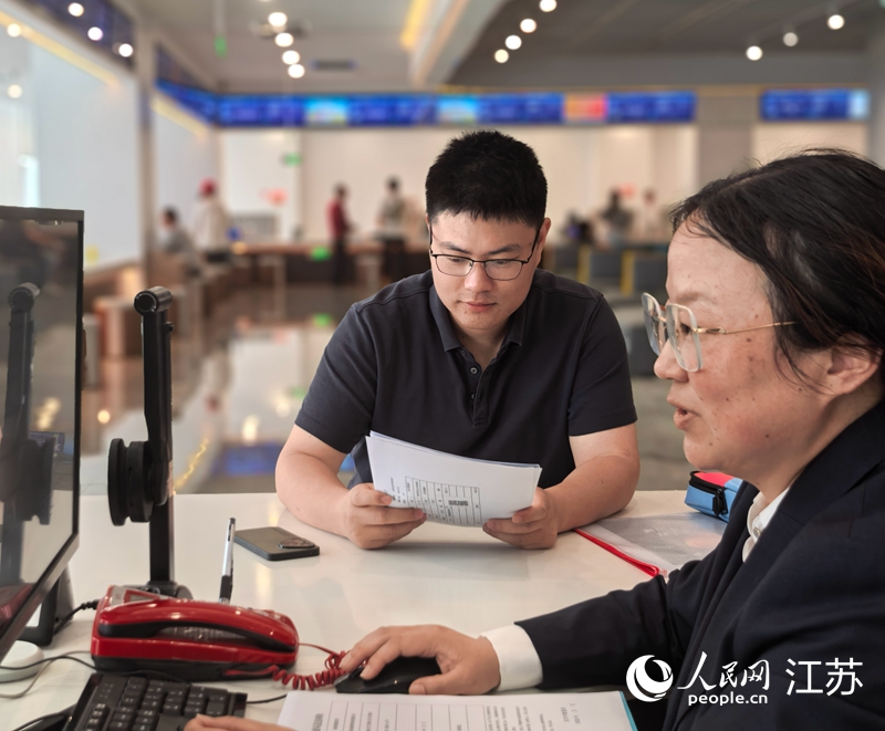 启东市数据局工作人员为企业办理行政审批事项。人民网记者 王继亮摄