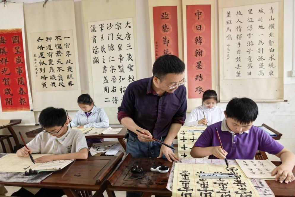 陈骁（前排右一）在老师指导下练字。人民网记者 王继亮摄