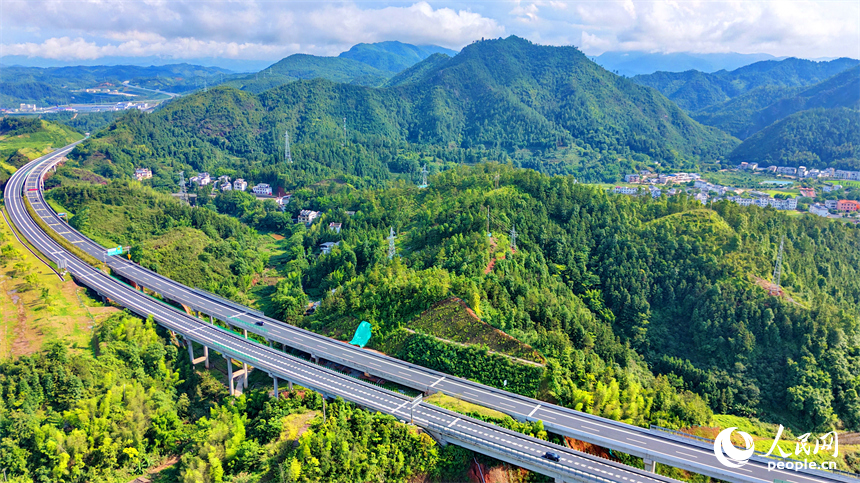 遂大高速公路江西省赣州市上犹县梅水乡园村大桥段，车辆往来驰骋，与村庄民居、群山绿树相映成景。人民网记者 朱海鹏摄