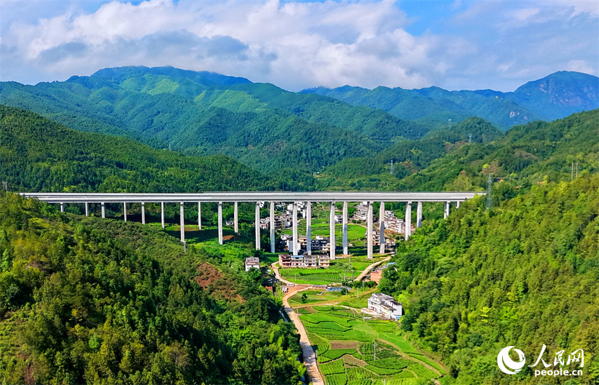 遂大高速公路江西省赣州市上犹县梅水乡园村大桥段，车辆往来驰骋，与村庄民居、群山绿树相映成景。人民网记者 朱海鹏摄