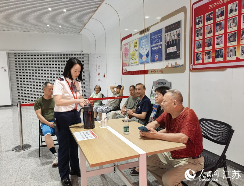 游璇为纳凉的市民送来饮用水。人民网记者 王继亮摄