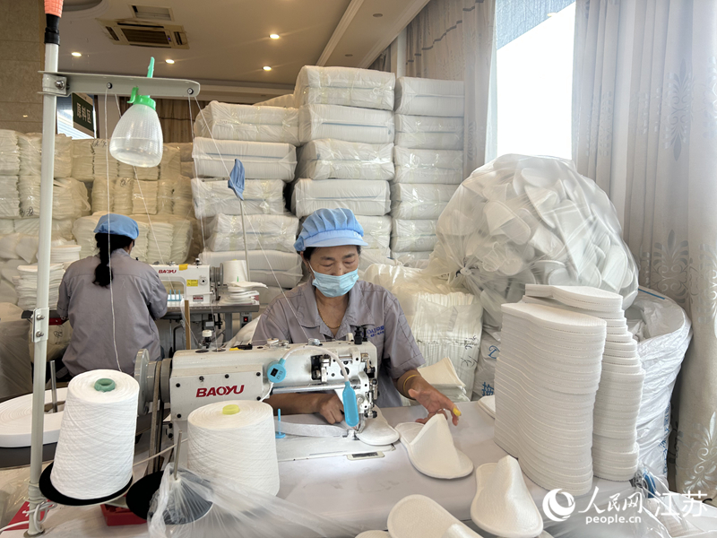 熊丽兰正在给拖鞋锁边。人民网记者 王丹丹摄