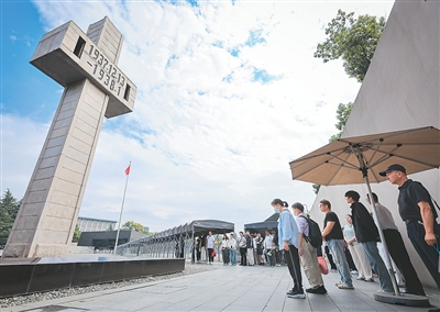 在侵华日军南京大屠杀遇难同胞纪念馆，人们在防空警报声中肃立默哀。苏 阳摄（新华社发）