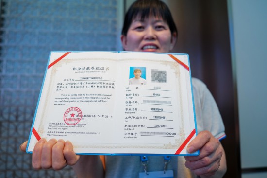 4月28日,长期照护师代表展示自己的“000001”编号证书。