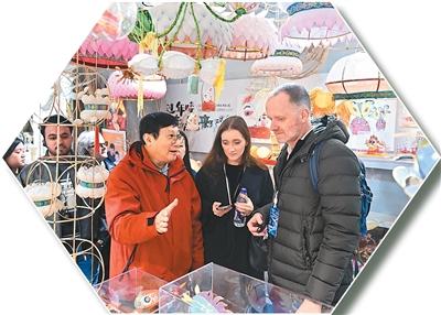 “世界市长对话·南京”活动期间，秦淮灯彩艺人、国家级非物质文化遗产代表性传承人顾业亮（右三）向嘉宾介绍秦淮灯彩。