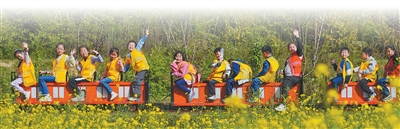 重庆市北碚区歇马街道虎头村，青少年们乘坐小火车感受乡村田园之美，乐享春日假期。秦廷富摄