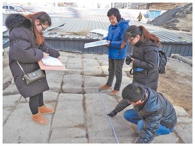 考古人员在测量太原镇远桥遗址的石块宽度。资料图片