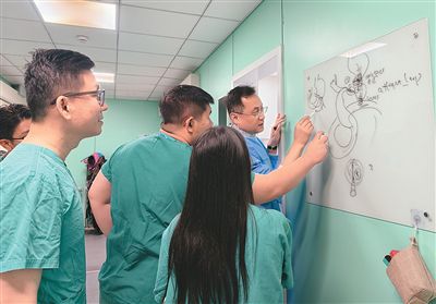 家属商量间隙，南京鼓楼医院消化内科行政主任、主任医师王雷为学员讲解手术思路。本报记者 尹晓宇摄